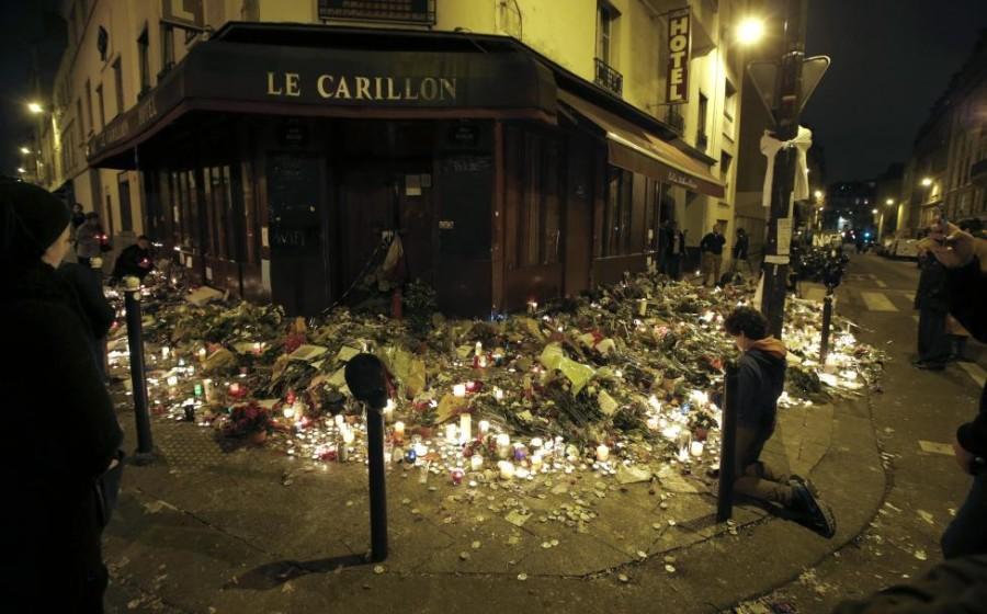 People pray outside Le Carillon restaurant, one of the attack sites in Paris, November 15, 2015. REUTERS/Jacky Naegelen