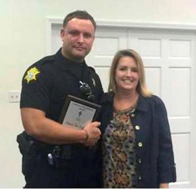 Richland County Sheriff's Department Officer Senior Deputy Ben Fields is pictured with Karen Beaman (R), Principal of Lonnie B. Nelson Elementary School after receiving Culture of Excellence Award at Lonnie B. Nelson Elementary School in Columbia, South Carolina on November 12, 2014.  REUTERS/Richland County Sheriff's Department/Handout